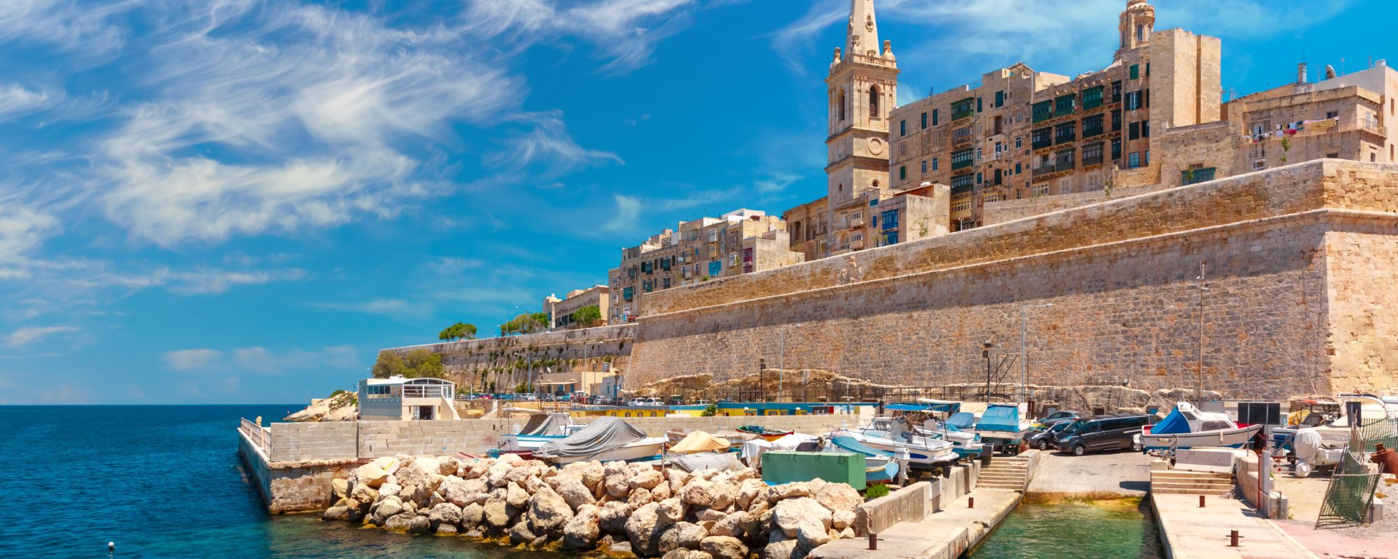 Valletta Skyline with fortress wall, boat pier and St. Paul's Anglican Pro-Cathedral, Valletta, Capital city of Malta. View from the sea